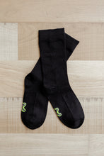 Load image into Gallery viewer, A pair of crew length black Sensory Friendly Clothing Seamless Feel Socks with the non irritating logo exposed on the sole.
