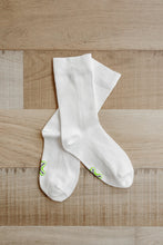 Load image into Gallery viewer, A pair of crew length white Sensory Friendly Clothing Seamless Feel Socks with the non irritating logo exposed on the sole.
