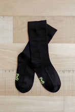 Load image into Gallery viewer, A pair of crew length black Sensory Friendly Clothing Seamless Feel Socks with the non irritating logo exposed on the sole.
