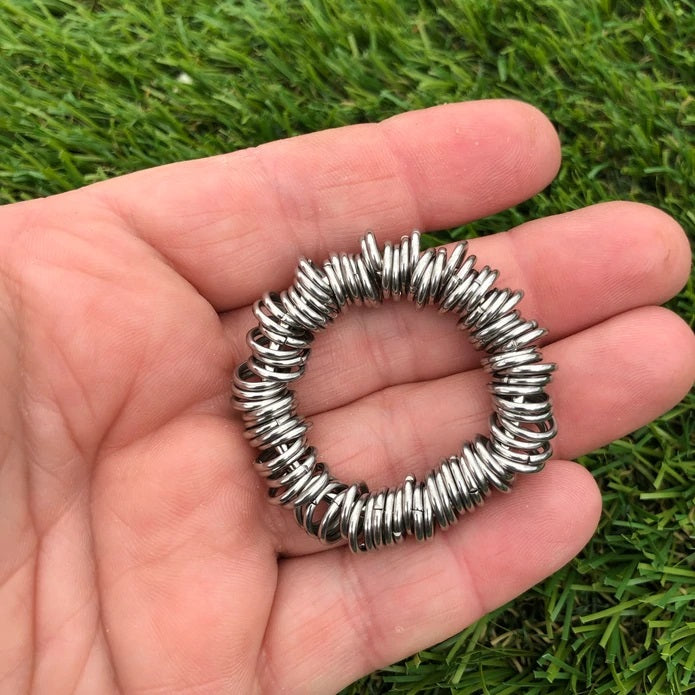 Kaiko Centipede Fidget made of steel being held in a hand.