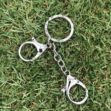 Load image into Gallery viewer, Kaiko Fidget Clip placed on green grass.
